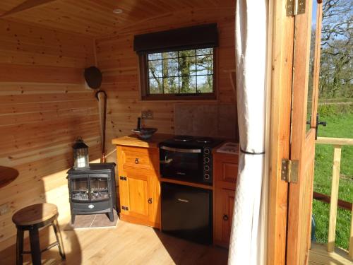una cocina en una cabaña de madera con fogones en The Lazy Shepherd, en East Pennard