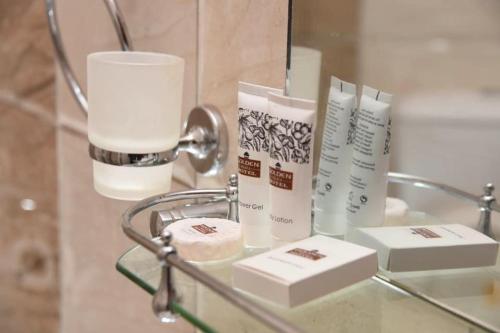 Una mesa de cristal con algunos productos encima en un baño. en Golden Palace Hotel, en Eldoret