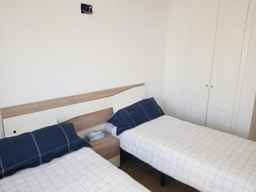 2 camas con almohadas azules en una habitación en Corvera Golf Holiday Home en Murcia