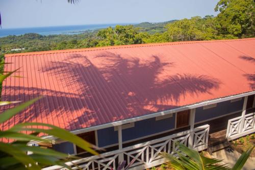 a building with a red roof with a palm tree on it at Coco Bahia Apartment in Six Huts