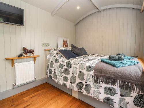 um quarto com uma cama com um edredão em The Moorhen Retreat em Oswestry