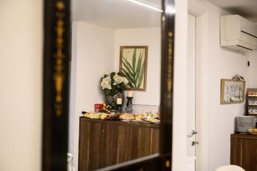 a hallway with a mirror and a dresser with flowers at Dream House Pompei in Pompei