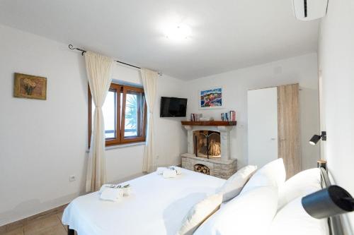 a bedroom with two beds and a fireplace at Seafront Villa Endless View in Blato