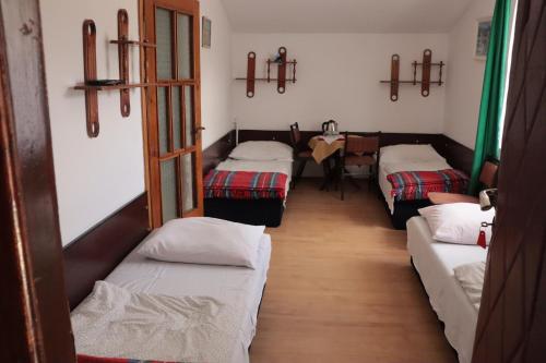 uma fila de camas num quarto com cruzes na parede em Dom Wczasowy Pod Weską em Korbielów