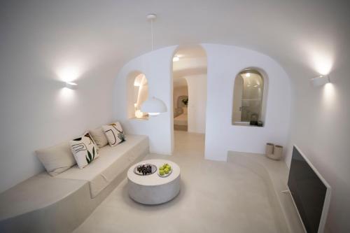 Sala de estar blanca con sofá y mesa en Kyrkos Residency by SV, en Oia