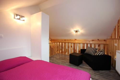 a bedroom with a bed and a couch in a room at Apartments Klemenčič in Bohinj
