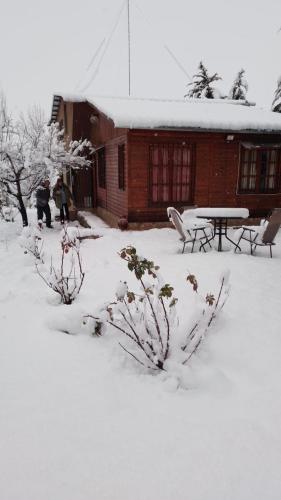 a snow covered yard with a picnic table and a building at La Perla in Ciudad Lujan de Cuyo
