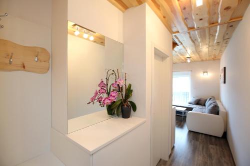 a living room with a couch and flowers on a shelf at Apartments Klemenčič in Bohinj