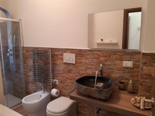 uma casa de banho com um lavatório, um WC e um espelho. em San Donato Apartment em Turim