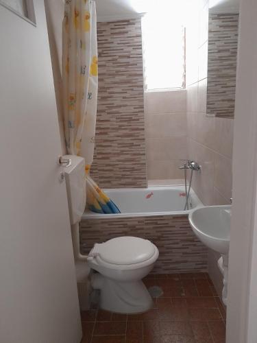 a bathroom with a toilet and a tub and a sink at Condo in Kalamata - Park View in Kalamata