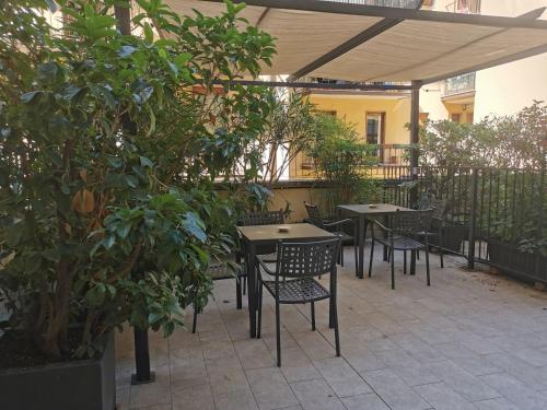 een patio met tafels, stoelen en bomen bij B&B Fralillo in Verona