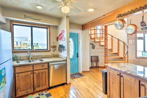 a kitchen with a sink and a refrigerator and a staircase at Secluded Beachfront Gem on Alligator Point! in Sun N Sand Beaches