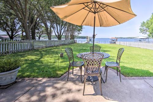 a table with two chairs and an umbrella at Lakefront Mabank Gem with Sunset Views Pets Welcome in Mabank
