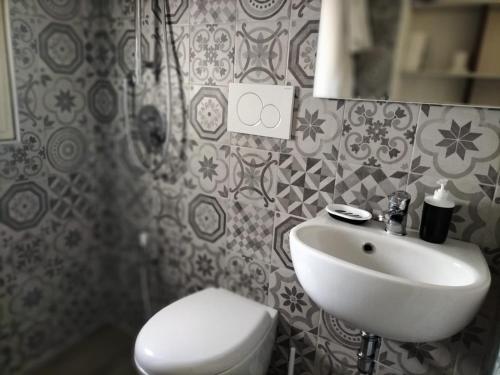 a bathroom with a white sink and a toilet at Casetta Angelini in Locorotondo