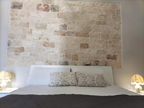 a bedroom with a brick wall and a bed at Casetta Angelini in Locorotondo