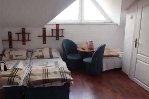 Zimmer mit 2 Betten, einem Tisch und einem Fenster in der Unterkunft Dom Wczasowy Pod Weską in Korbielów