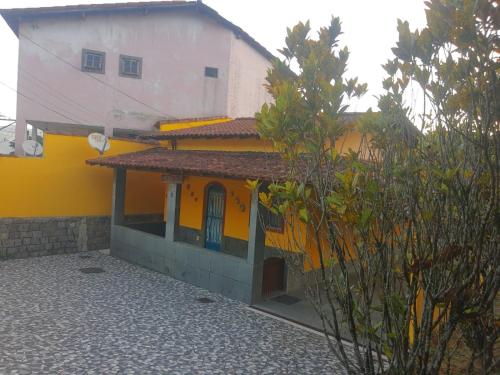 uma casa amarela e branca com um edifício em CASA COMPLETA-CONCEIÇÃO DE JACAREÍ -COSTA VERDE em Mangaratiba