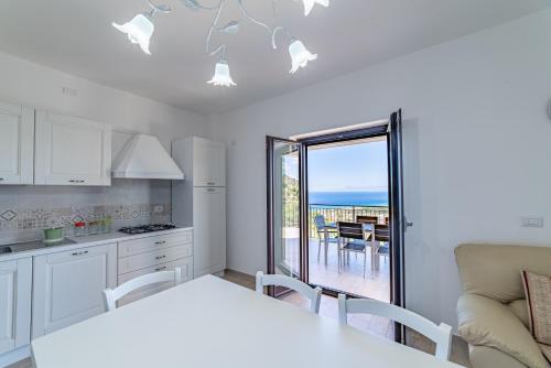eine Küche und ein Esszimmer mit Blick auf das Meer in der Unterkunft Casa Vacanze Il Vigneto in Castellabate