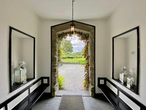 a hallway with two mirrors and a doorway at Crow How Country Guest House in Ambleside