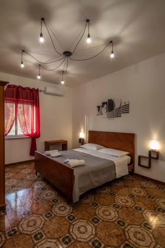 a bedroom with a large bed and a red window at La Valle di Hermes in Piraino