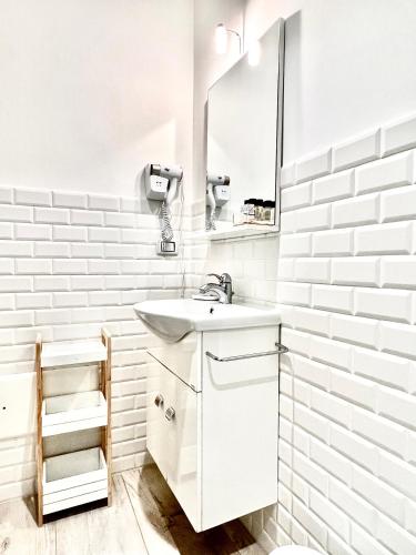 a white bathroom with a sink and a mirror at Eccelsoleccese Boutique B&B - steps from the Historic Center in Lecce