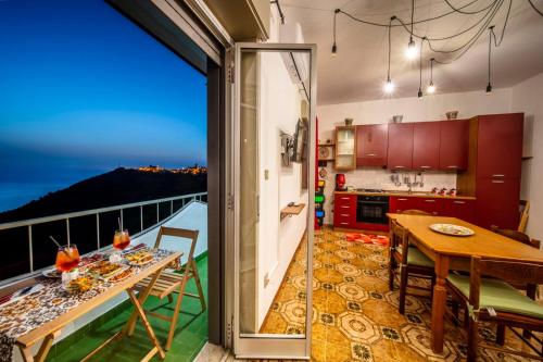 cocina y comedor con vistas a un balcón en La Valle di Hermes en Piraino