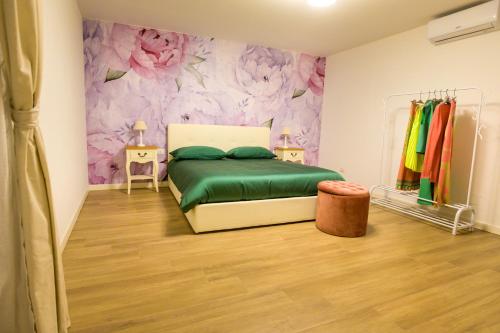a bedroom with a bed and a floral wall at Sweet House in Nocera Inferiore