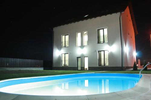 una casa por la noche con una piscina delante en Sunrise Villa, en Băile Felix