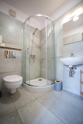 ein Badezimmer mit Dusche, Toilette und Waschbecken in der Unterkunft Swoboda na szczycie góry z dala od miasta in Brenna