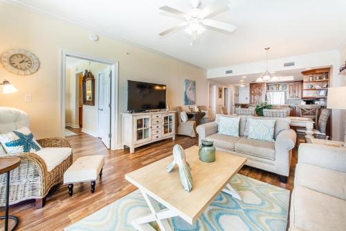 a living room with a couch and a tv at Boardwalk 1502 in Panama City Beach