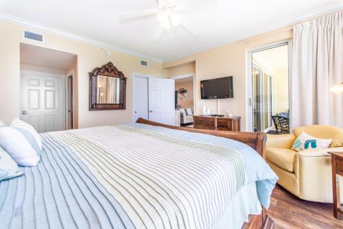 a bedroom with a bed and a couch and a tv at Boardwalk 1502 in Panama City Beach