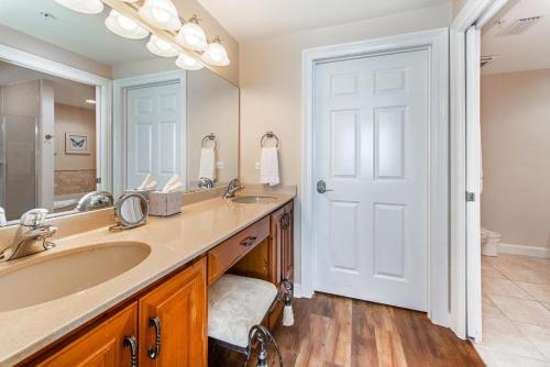 a bathroom with a sink and a large mirror at Boardwalk 1502 in Panama City Beach