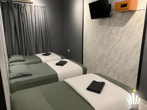 - 2 lits dans une petite chambre avec un miroir dans l'établissement Malim Melaka Homestay, à Malacca