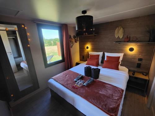 a bedroom with a large bed with a window at Domaine des graminées in Jeanménil