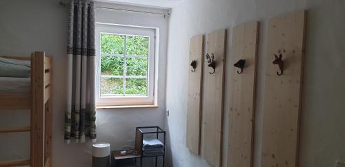 a bedroom with wooden panels on the wall and a window at Wanderstube Landsonne in Simmerath