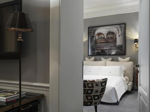 a bedroom with a bed and a table with a lamp at J.K. Place Roma - The Leading Hotels of the World in Rome