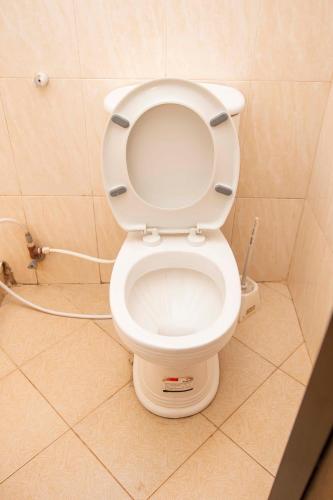 a bathroom with a toilet with the lid up at Klub Afriko Hotel Arusha in Arusha