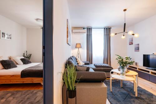 uma sala de estar com uma cama e um sofá em Cosy Apartment by LoftAffair em Cracóvia