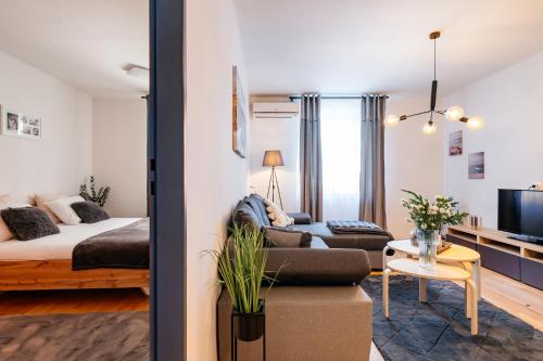 a living room with a bed and a couch at Cosy Apartment by LoftAffair in Krakow