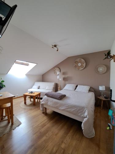 a bedroom with a large white bed and a table at Halte Dodo in Tallard