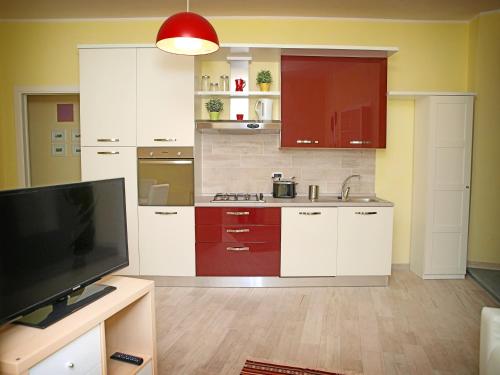 オルヴィエートにあるAppartamenti Pistrellaの白いキャビネットと薄型テレビ付きのキッチンが備わります。