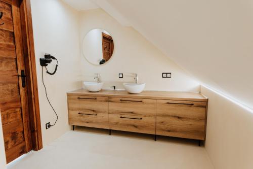a bathroom with two sinks and a mirror at Skava Apartments Zator Energylandia in Wadowice