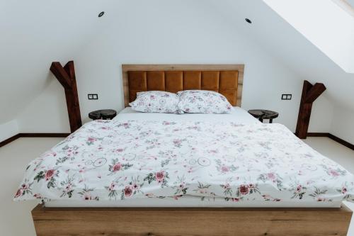 a bed with a floral bedspread and two pillows at Skava Apartments Zator Energylandia in Wadowice