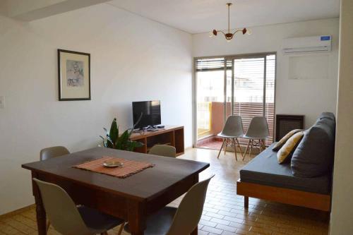 een woonkamer met een tafel en een bank bij Departamento céntrico y confortable in Mendoza