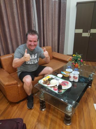 a man sitting on a couch giving thumbs up at New Airport Hotel in Noi Bai