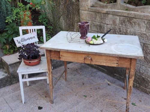 a wooden table with a plate of food and a chair at Appartement Eigelsreiter Lilienfeld in Lilienfeld