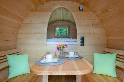 una casa pequeña con mesa y 2 sillas en Schlaffass Campingplatz Nordbrock en Hamminkeln