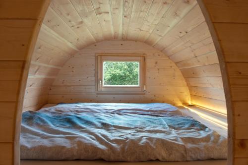 a bed in a small room with a window at Schlaffass Campingplatz Nordbrock in Hamminkeln