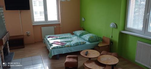 een kleine kamer met een bed en twee tafels bij Salatín in Ružomberok