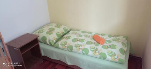 a small bed in a room with a pillow at Salatín in Ružomberok